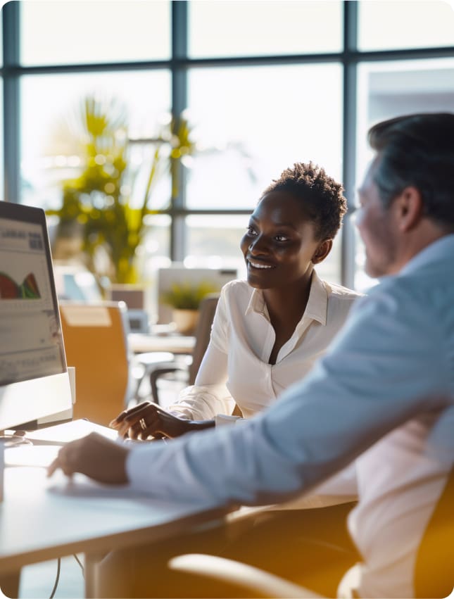 A manager and a Cura Connect consultant analyze production and labor reports on a computer screen, a testament to how Cura Connect empowers members with innovative processes for enhancing food production, minimizing waste, and efficiently sourcing food service talent to streamline operations."
