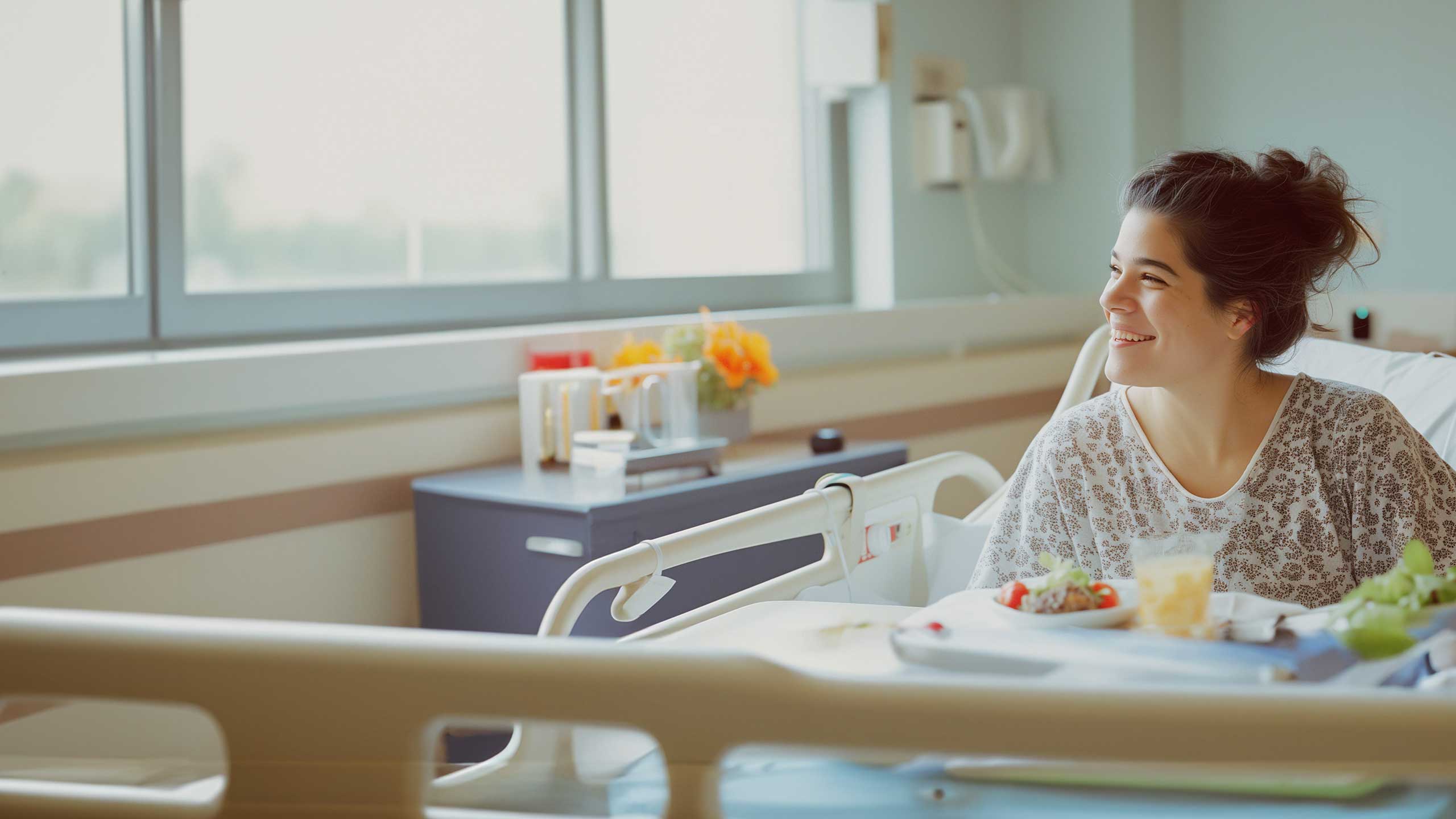 An acute care patient enjoys a moment of serenity by the window in her hospital room, with a carefully prepared meal from Cura Connect's healthcare culinary program on her tray
